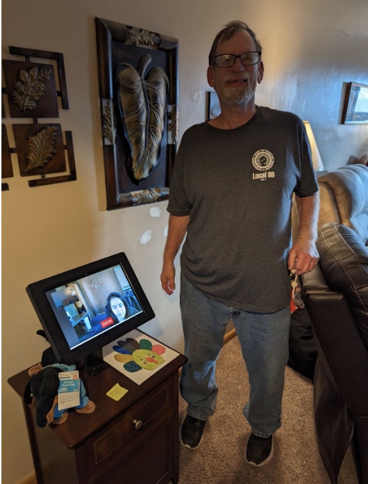 Screenshot man standing over computer