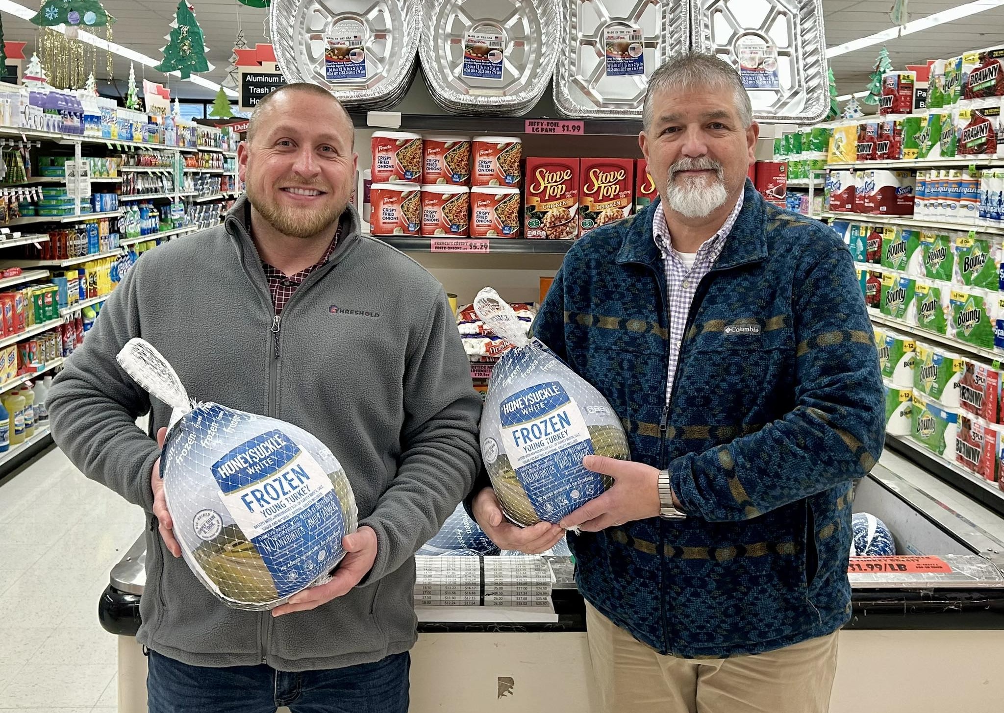 Threshold team members holding frozen turkeys